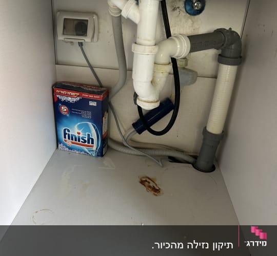 צנרת מתחת לכיור עם חומר ניקוי